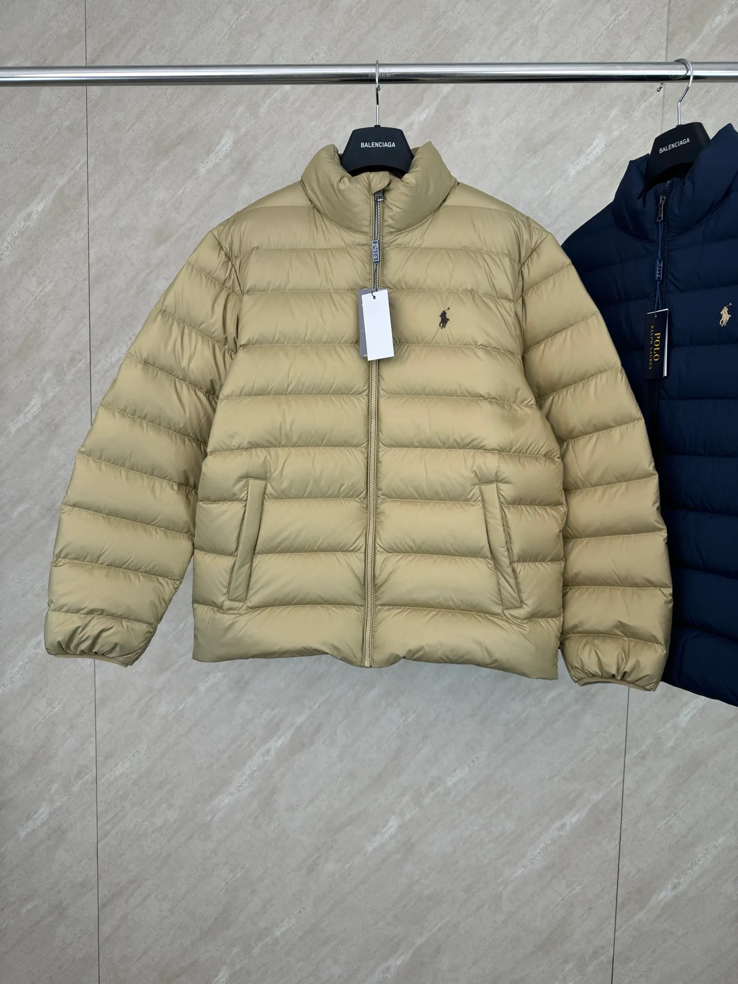 P930 Ralph Lauren lightweight down jacket size s m l xl The nylon fabric has good windproof and waterproof properties, which can effectively block the intrusion of wind and rain from the outside and keep the inside dry, suitable for wearing in humid or rainy environments.  The red label on the chest is made with an imported MECLO embroidery machine. The original pattern is scanned first, and then high-quality silk thread is used to make a pattern. The density effect is adjusted by continuous pattern making.  Exquisite details: the zipper design is simple and elegant, easy to operate; the closing design of the cuffs and hem effectively prevents the intrusion of cold wind, improving the warmth and comfort of wearing.  High-quality filling: 90 white duck down is selected, with a weight of 260g, ensuring excellent thermal insulation performance. After strict screening and processing, the velvet is not easy to drill, ensuring durability. The hangtags, wash marks, air holes, and four-button buttons are all customized from the original one-to-one mold.